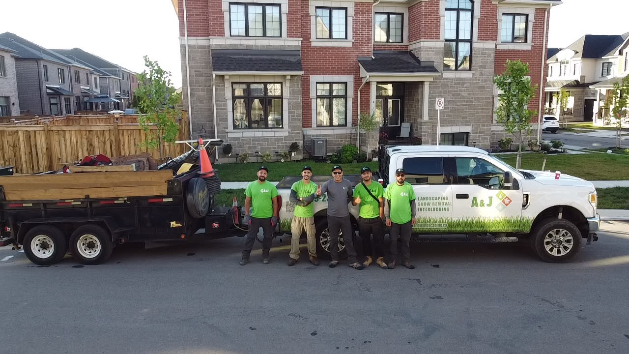 The A&J landscaping team with their work trucks
